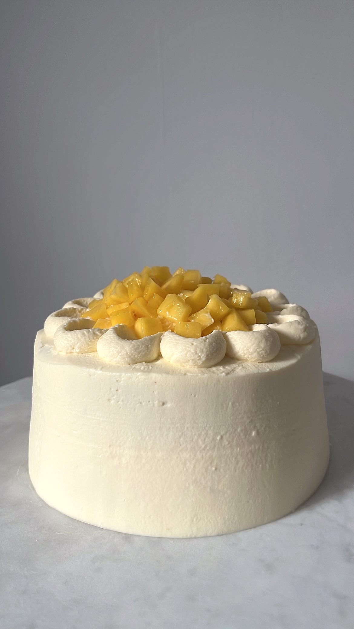 Cake topped with mango, enhancing its sweetness and flavor